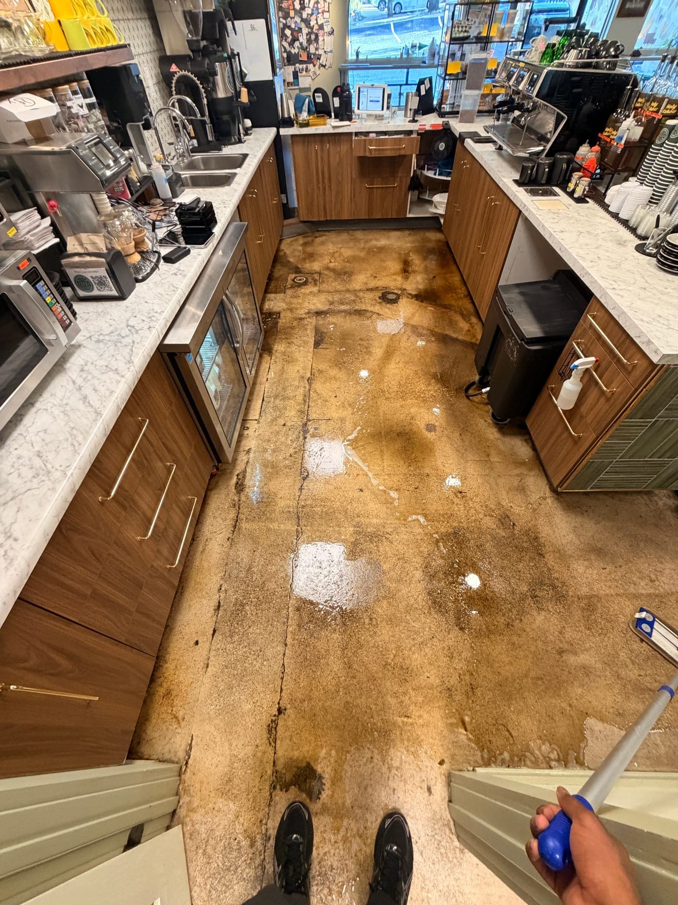 Heavily soiled concrete part-way through a degreasing pass, cleaned wet passes visible